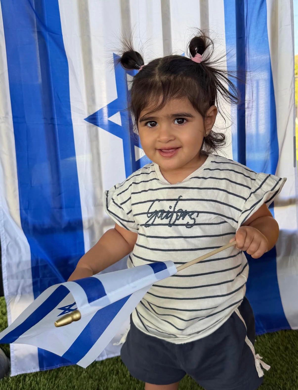 A toddler waving a flag on Yom Ha'atzmaut