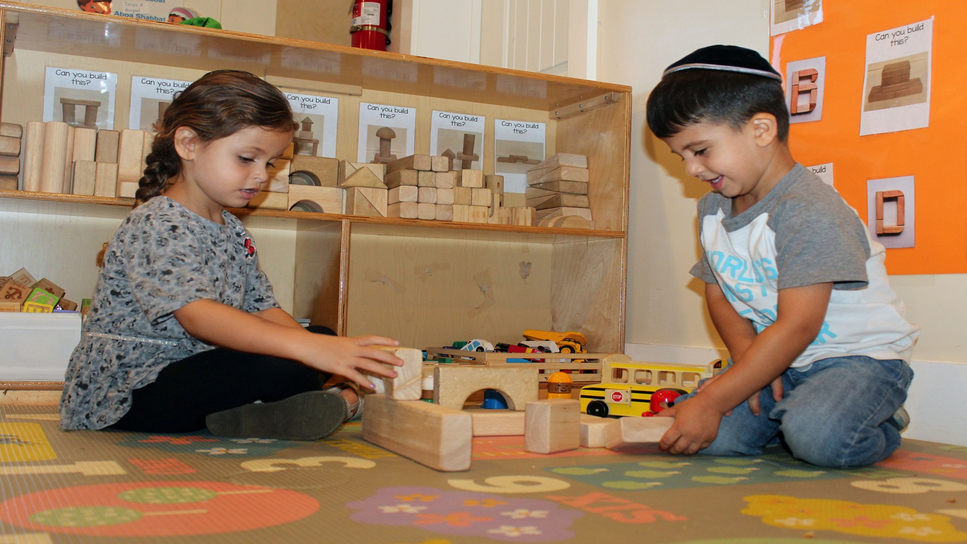 Two children building with wooden blocks in a Learn and Smile classroom